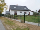 Oplocení z plotových panelů s betonovými podhrabovými deskami